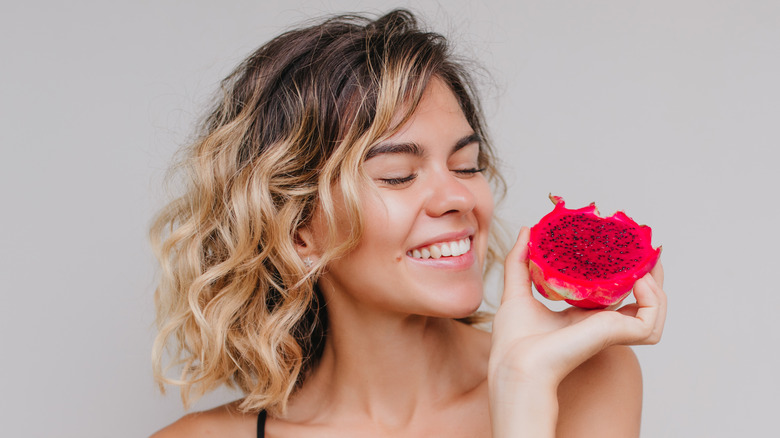girl smiling holding dragon fruit