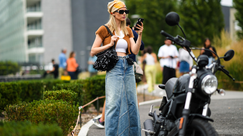 woman on phone wearing denim maxi