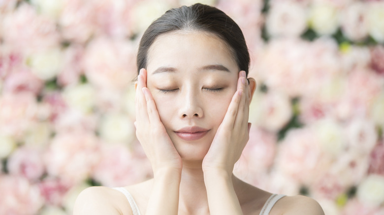 A woman touching her face. 