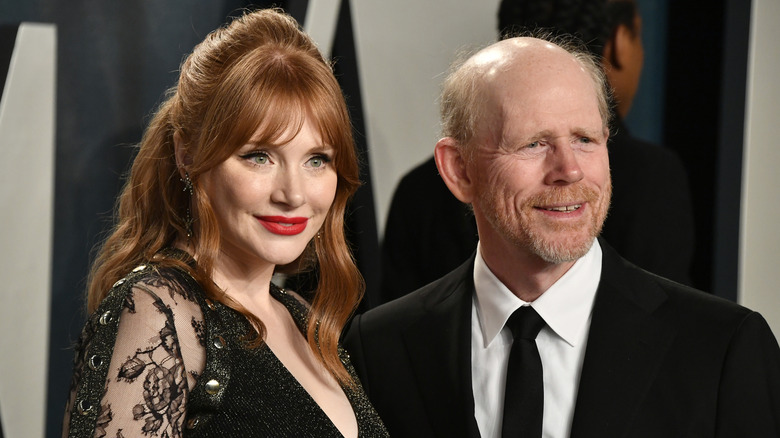Bryce Dallas Howard and Ron Howard smiling while posing at an event together