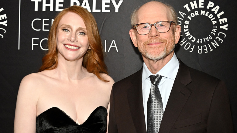 Bryce Dallas Howard and Ron Howard smiling while posing together at an event