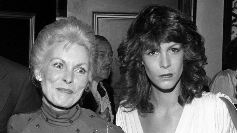 Janet Leigh smiling with wide eyes next to a stony-faced Jamie Lee Curtis