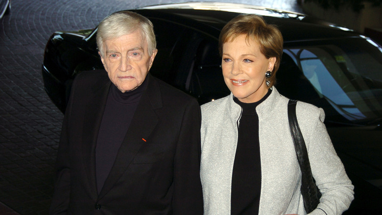 Blake Edwards and Julie Andrews in front of a car