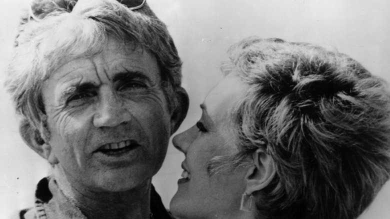 Blake Edwards wearing sunglasses on his head with wife Julie Andrews smiling next to him