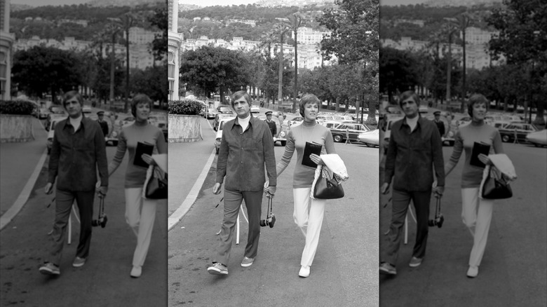 A black and white photo of Blake Edwards and Julie Andrews holding hands on the street