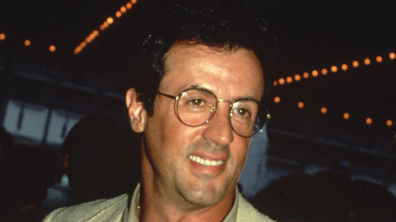 Sylvester Stallone smiling and wearing glasses