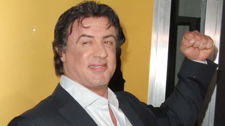 Sylvester Stallone smiling and raising his fist