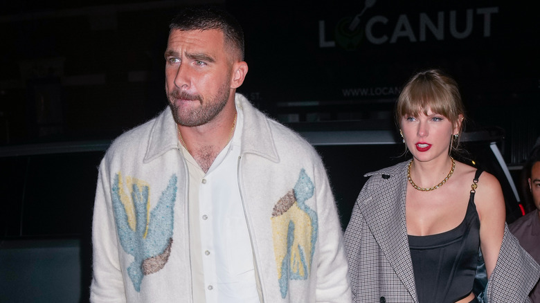 Travis Kelce and Taylor Swift walking into a restaurant