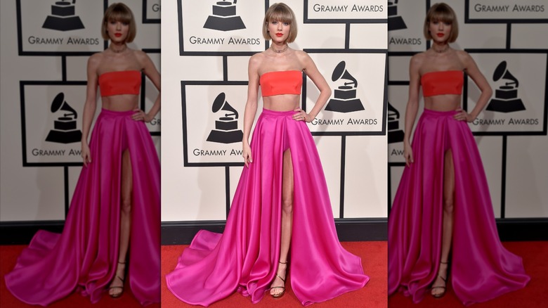 Taylor Swift wearing a coral bandeau top and pink skirt.