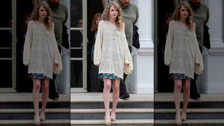 Taylor Swift walking down stairs in a crochet top.