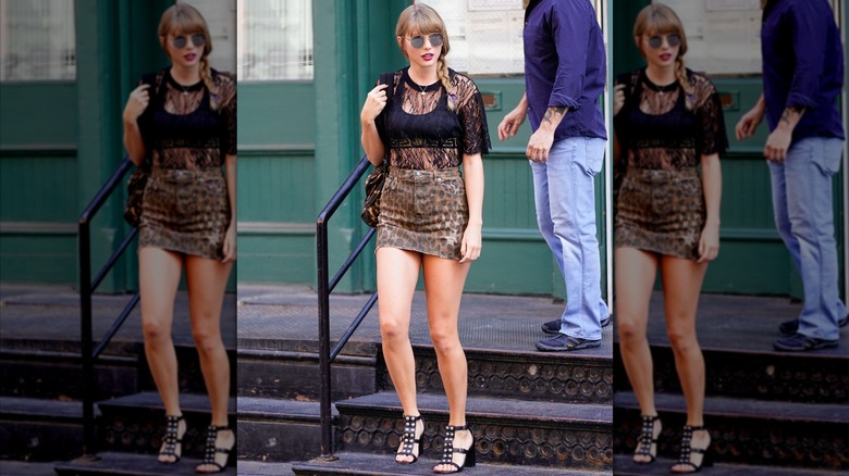 Taylor Swift walking down stars in a leopard-print miniskirt and lace top.