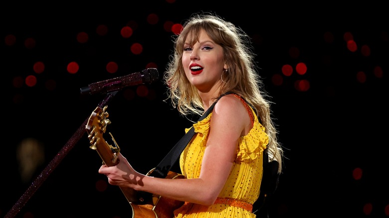 Taylor Swift smiling, holding guitar