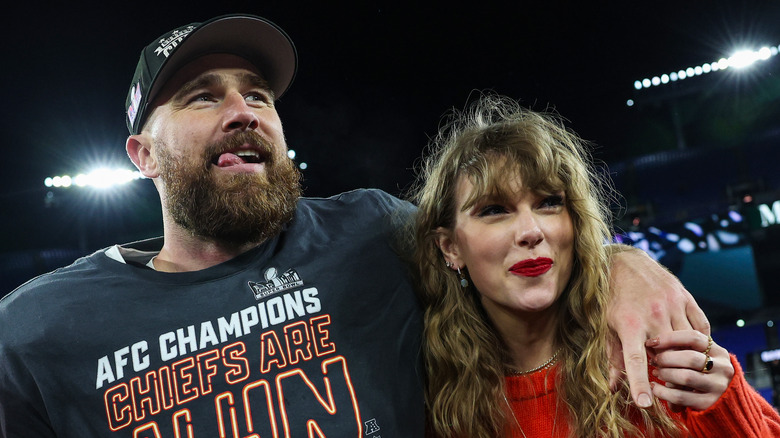 Travis Kelce and Taylor Swift stand together on football field