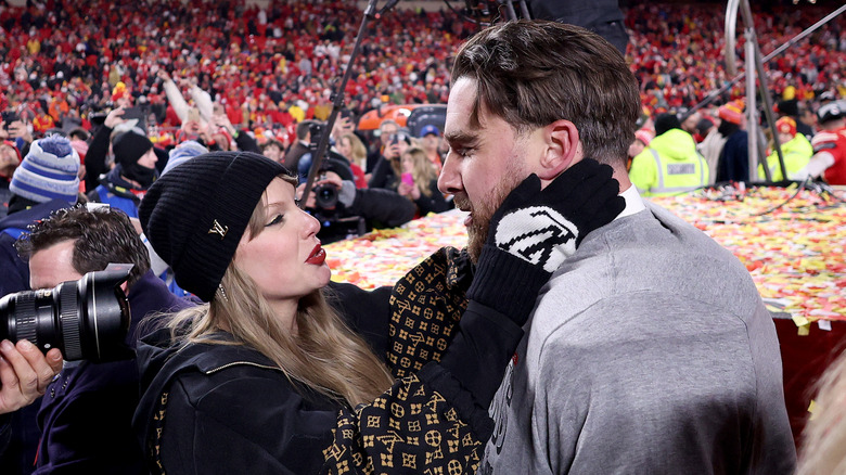 Taylor Swift looking at Travis Kelce on the field after a football game