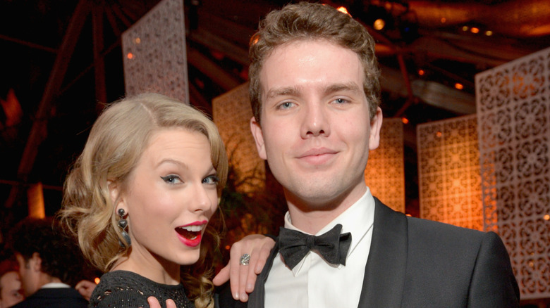 Taylor and Austin Swift posing together at a black tie event