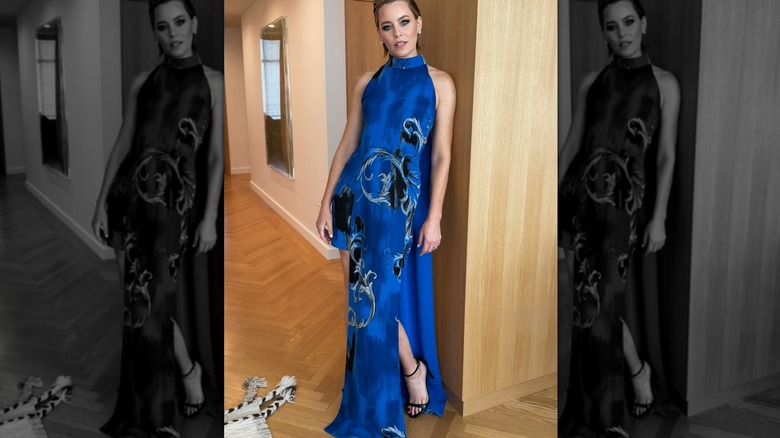 Elizabeth Banks leaning against a wall in a blue dress