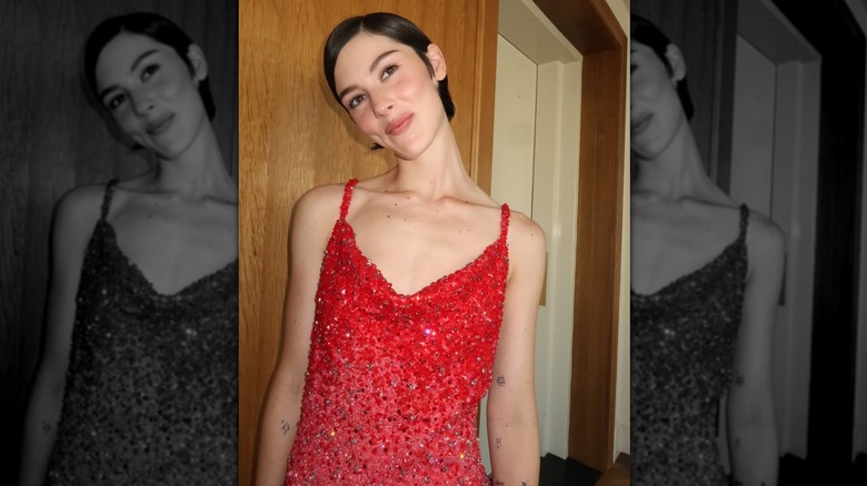 Gracie Abrams smiling in a sparkling red dress