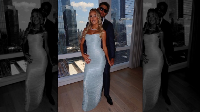 Brittany and Patrick Mahomes, hand-in-hand, smiling in front of a view of the New York skyline