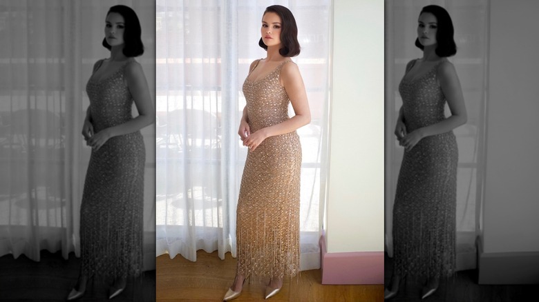 Selena Gomez wearing a champagne-colored dress in front of a sheer curtain