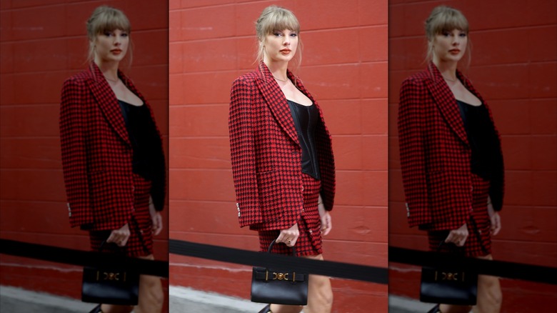 Taylor Swift in a red two piece suit with a black shirt
