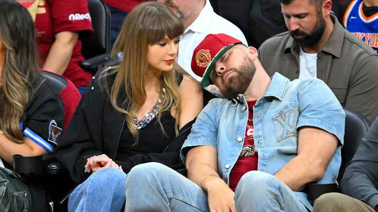 Taylor Swift looks at Travis Kelce as he pretends to snooze