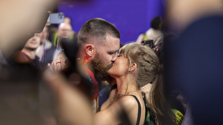 Travis Kelce and Taylor Swift kissing on the field after the 2024 Super Bowl