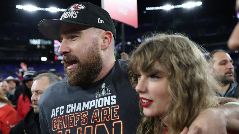 Taylor Swift and Travis Kelce smiling at a game
