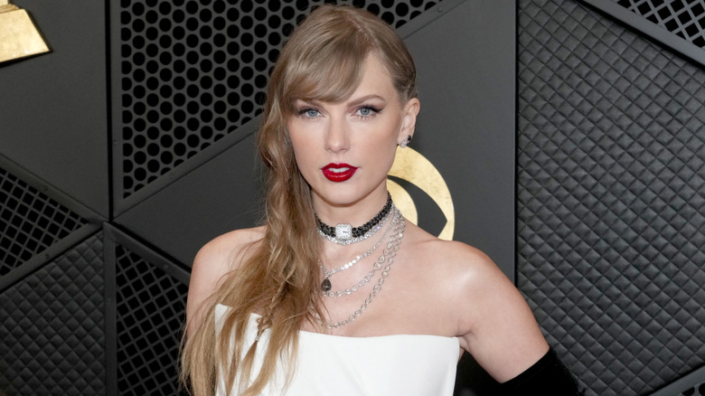 Taylor swift wearing white dress with long black gloves