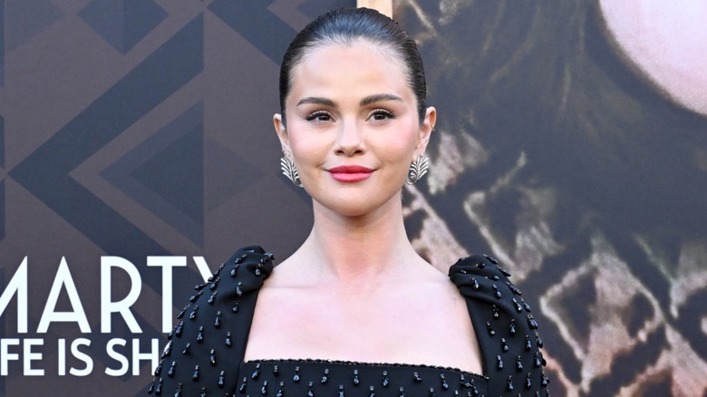 Selena Gomez wearing silver earrings and a black dress.