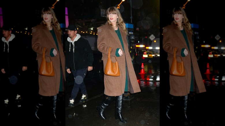 Taylor Swift walking and looking over her shoulder in large winter coat.