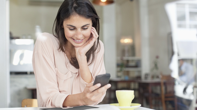 Smiling woman texting on phone