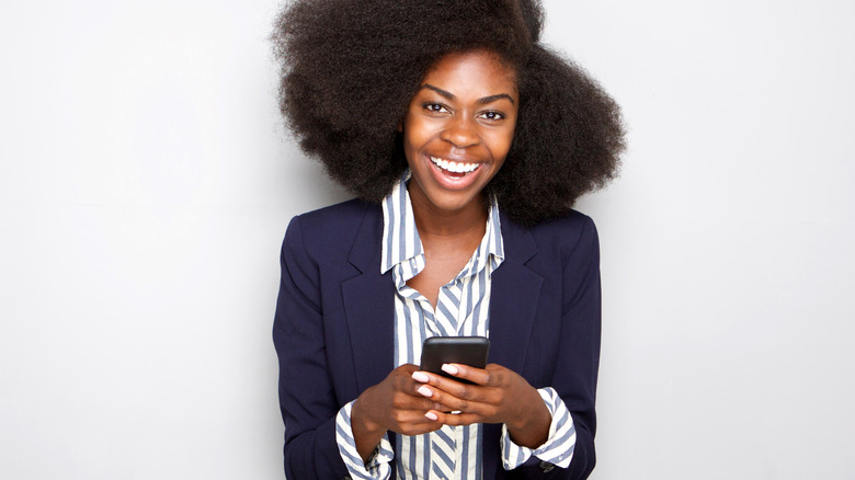 woman laughing and texting