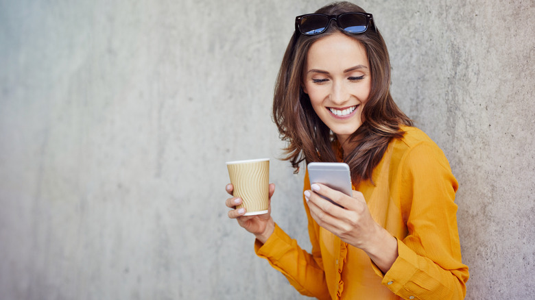 woman drinking coffee and texting