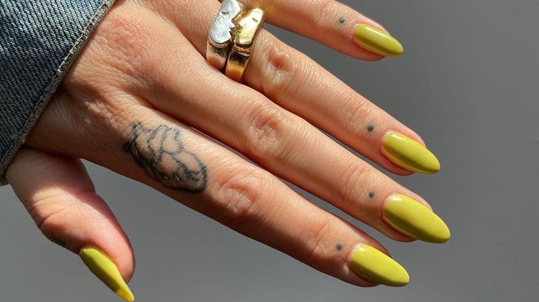 Hand with chartreuse nail color