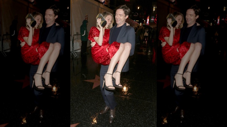 Topher Grace carrying his wife Ashley while the couple smile and laugh on the Hollywood walk of fame