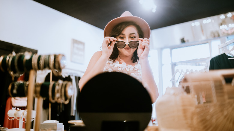 Woman trying on sunglasses in store