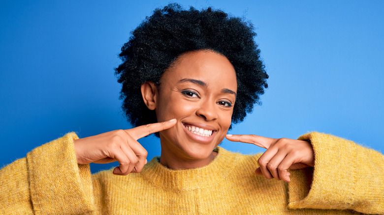 Black model pointing at her happy smile