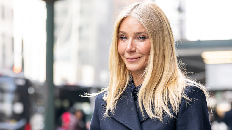 Street shot of Gwyneth Paltrow smiling against a blurred background