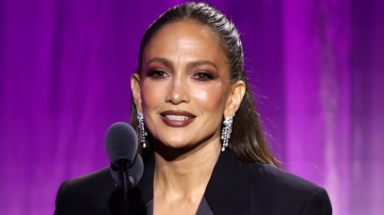 Jennifer Lopez in full makeup facing a mic
