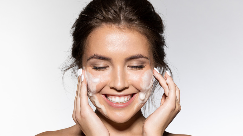 Young woman cleaning face