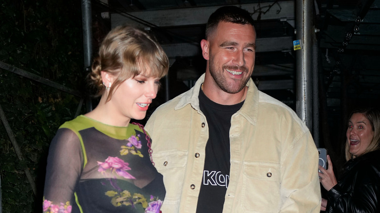 Taylor Swift and Travis Kelce smiling on the town
