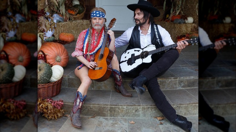Jessica Simpson wearing a Willie Nelson costume with shorts and Eric Johnson seated beside her in a Waylon Jennings costume
