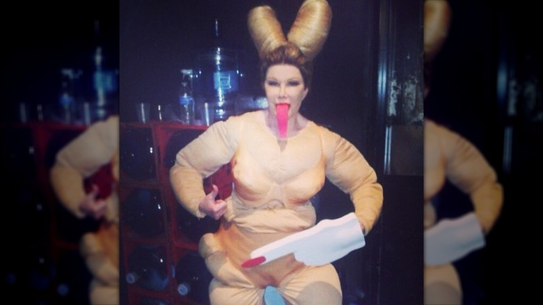 Joan Rivers wearing a Miley Cyrus costume with oversized space buns, a stuffed nude bodysuit, and long fake tongue