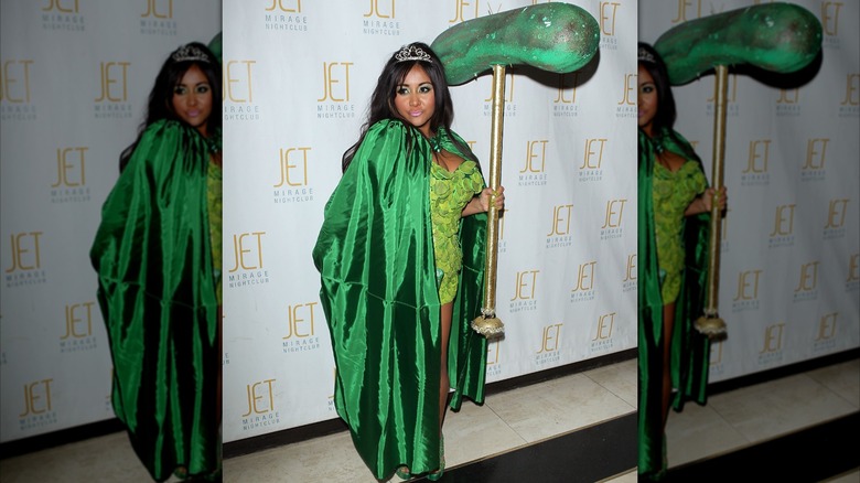 Snooki wearing a dress covered with fake dill pickle slices and holding a pickle scepter