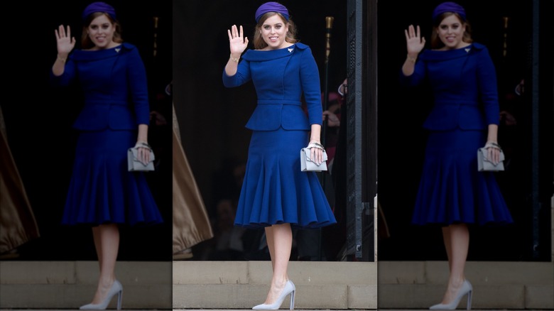 Princess Beatrice in a blue skirt suit, grey heels, and purple hat