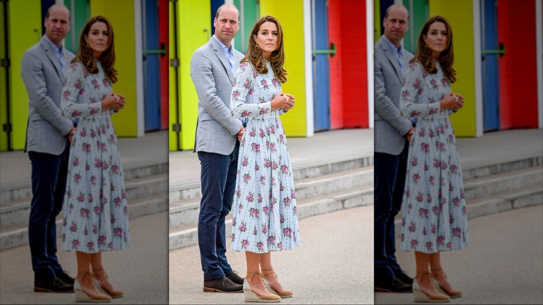 Kate Middleton in a blue dress and wedges with Prince William standing outside