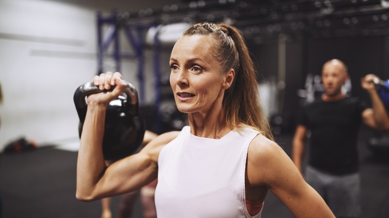 A woman lifting a kettlebell 