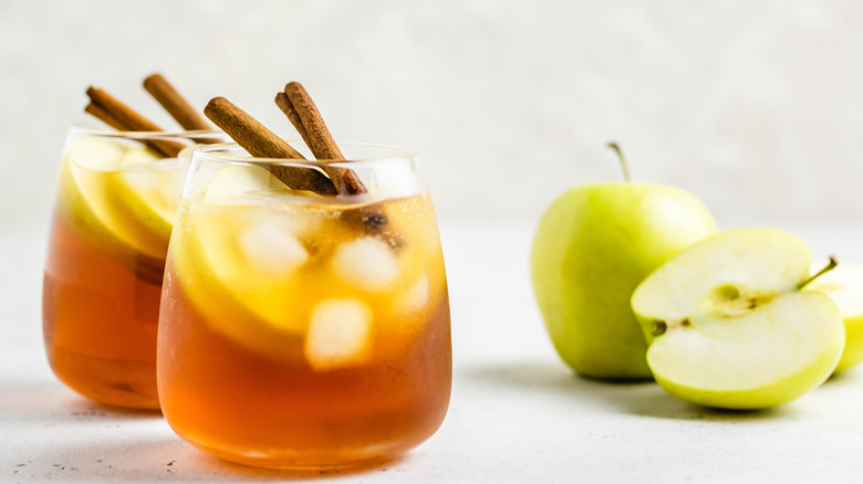 Cocktails with cinnamon sticks and apples