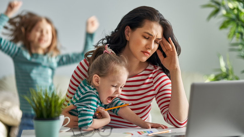 Mother trying to work on computer with small children