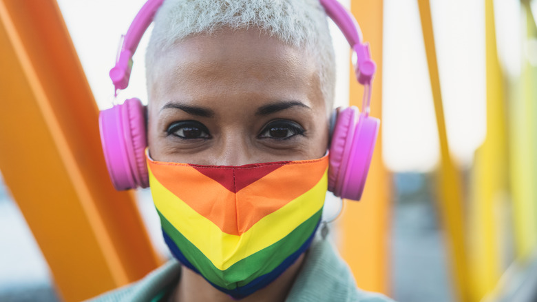 A person wearing headphones and a LGBTQ Pride mask